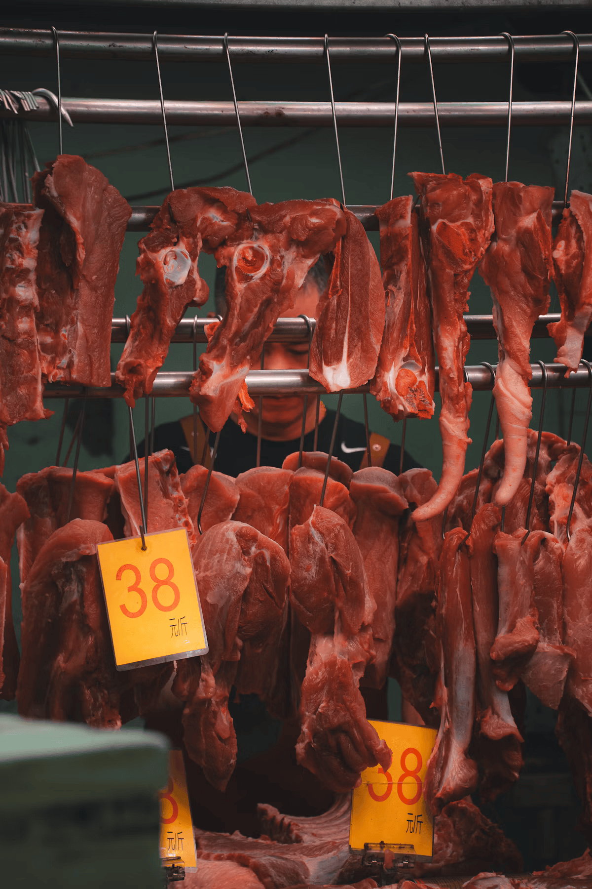 Fresh meat hanging in a butcher shop display, tracked as tightly as any packaged SKU